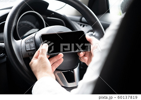スマートフォンを操作しながら運転している男 スマートフォンを操作しながら運転している男 60137819