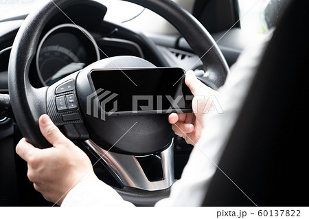 スマートフォンを操作しながら運転している男 60137822