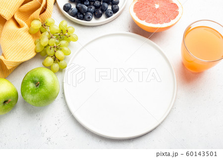 Fresh organic fruits, fruit juice and empty white plate 60143501