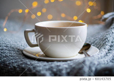 Cup of coffee with milk on cozy knitted winter blanket Cup of coffee with milk on cozy knitted winter blanket 60143705