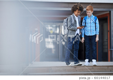 Two friends using phone after school 60144017
