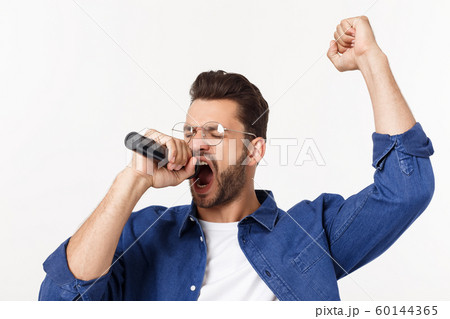 Portrait of an excited young man in t-shirt isolated over gray backgound, singing. Portrait of an excited young man in t-shirt isolated over gray backgound, singing. 60144365