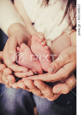 mom and dad are holding baby legs 60148817