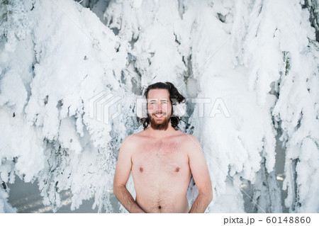 Topless young man outdoors in snow in winter forest, looking at camera. Topless young man outdoors in snow in winter forest, looking at camera. 60148860
