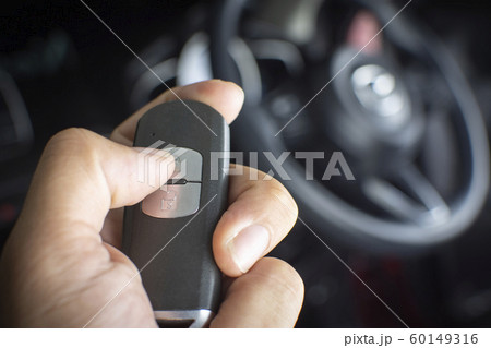 The driver's hand is pressed to the remote car keyless. 60149316