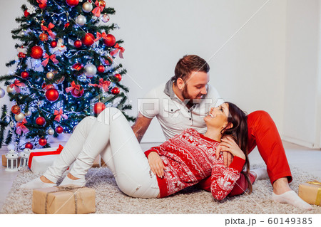 the guy with the girl lying on the floor at the new year Christmas tree the guy with the girl lying on the floor at the new year Christmas tree 60149385