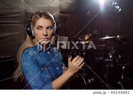 Female singing a sing at recording studio. Female singing a sing at recording studio. 60149892