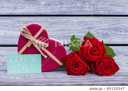 Heart shaped gift box and red roses. 60150547