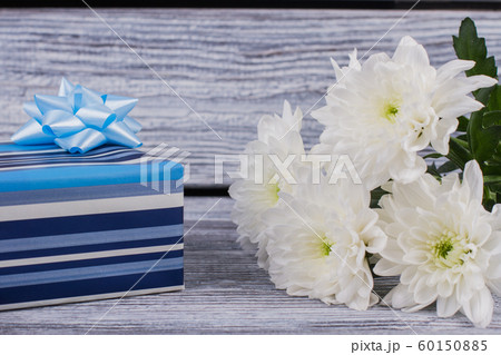 Blue gift box and white chrysanthemums. Blue gift box and white chrysanthemums. 60150885