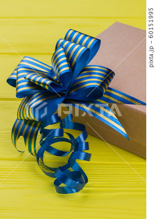 Cardboard gift box with blue striped ribbon bow knot. Cardboard gift box with blue striped ribbon bow knot. 60151995