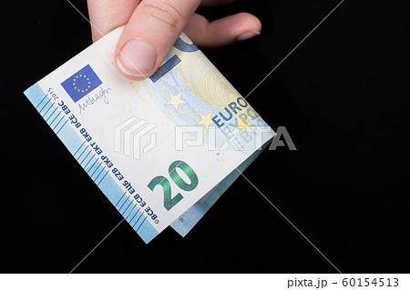 Hand holding 100 euro banknote on a black 60154513