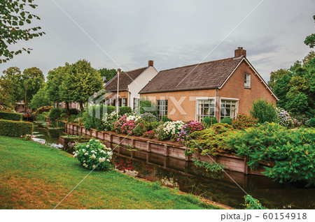 Canal next to rustic houses with flowery garden at Drimmelen Canal next to rustic houses with flowery garden at Drimmelen 60154918