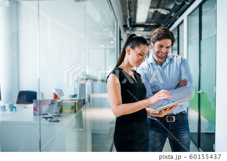 Young businesspeople with clipboard in an office, working. 60155437