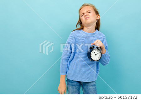 european girl holding an alarm clock on a light blue background european girl holding an alarm clock on a light blue background 60157172