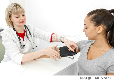 Physiotherapist puts on a medical tonometer to Physiotherapist puts on a medical tonometer to 60157871