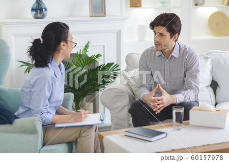 Stressed man talking to psychotherapist at private cabinet 60157978