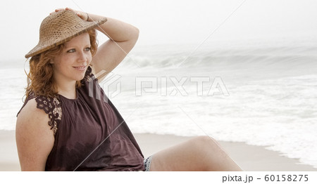 Young woman relaxes on the beach during her summer vacation 60158275