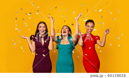Three Multiethnic Girls In Dresses Having Fun Under Falling Confetti, Studio Three Multiethnic Girls In Dresses Having Fun Under Falling Confetti, Studio 60158638