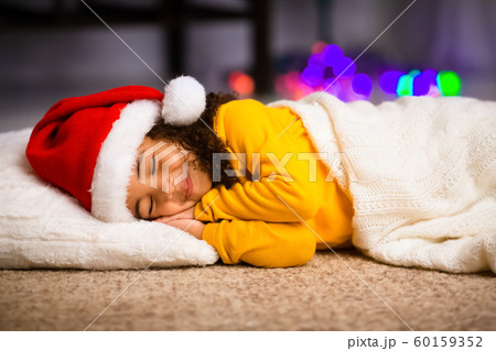 Cheerful african little girl in Santa hat enjoying sweet dream 60159352