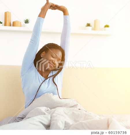 Happy Black Girl Waking Up Stretching Arms Sitting In Bedroom Happy Black Girl Waking Up Stretching Arms Sitting In Bedroom 60159736