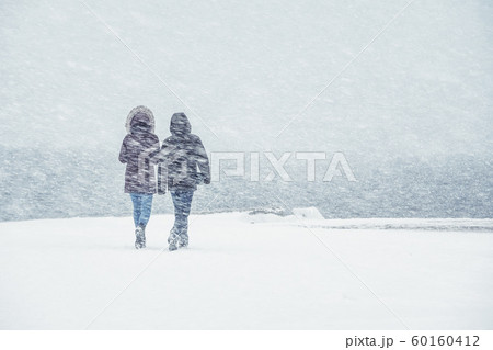 A couple walks in heavy snow. A couple walks in heavy snow. 60160412