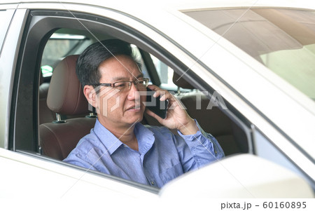 Businessman smiling and talking on his cell phone 60160895
