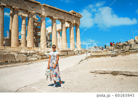Ancient temple Parthenon in Acropolis Athens Greece and portrait of young woman on a bright blue sky 60163945
