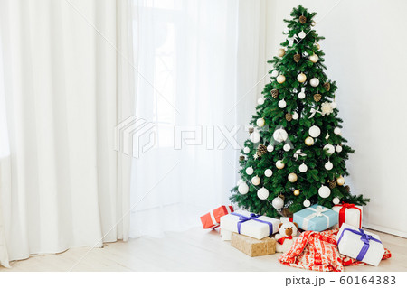 green Christmas tree with gifts in the interior of the white room New Year green Christmas tree with gifts in the interior of the white room New Year 60164383