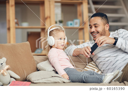 Little Girl Listening to Music with Dad 60165390