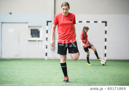 Active girl in sports uniform working out on football field before game Active girl in sports uniform working out on football field before game 60171869