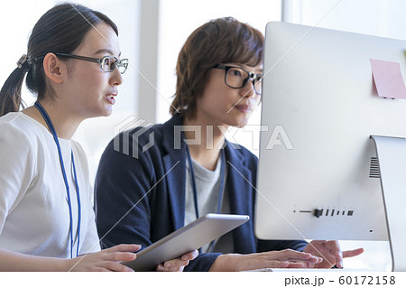 オフィスワーク イメージ パソコンの画面を見る若い男女 オフィスワーク イメージ パソコンの画面を見る若い男女 60172158