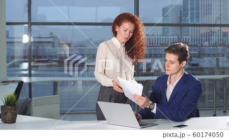 Female employee of the company brings financial documents to his boss Female employee of the company brings financial documents to his boss 60174050