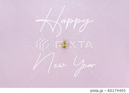 New Year celebration concept. Golden Christmas ball, lettering and golden star sequins on pastel 60174405