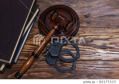 Handcuffs and a wooden gavel in front of manila 60175525