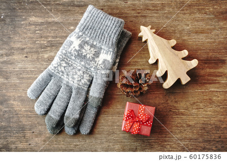 Topview sweater gloves and red gift box and small hand craft christmas tree and pine cone lay on vintage wood 60175836