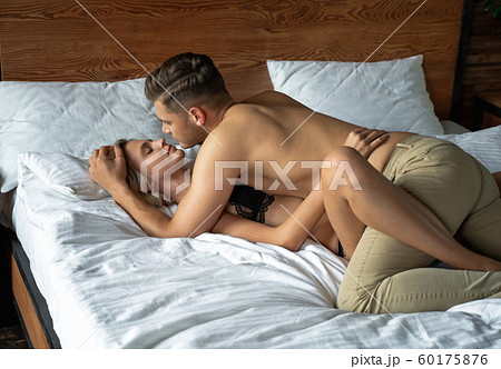 Pretty woman with eyes closed lying in bed with girlfriend 60175876