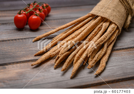 Italian traditional rye bread grissini on linen bag on wooden background. Close up 60177403