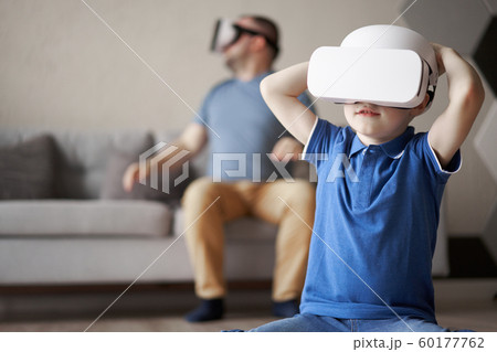 Young dad and son in glasses of virtual reality in apartment Young dad and son in glasses of virtual reality in apartment 60177762