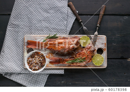 Hot smoked fish on a wooden cutting board. Red sea bass Hot smoked fish on a wooden cutting board. Red sea bass 60178398