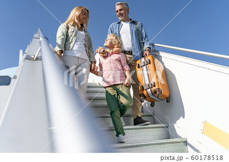 Happy mother looking at her little son on gangway of plane 60178518