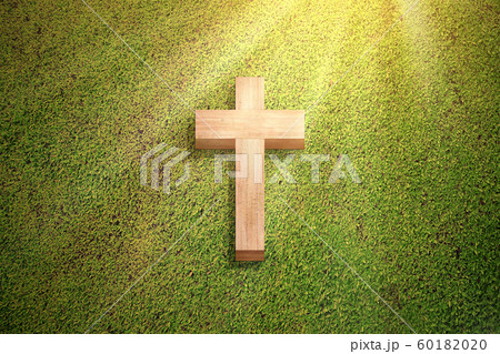 Christian cross on the green grass 60182020