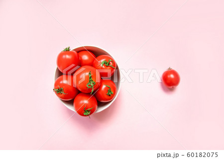 Fresh red tomatoes in a bowl on a pink background 60182075