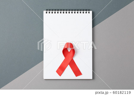 Red HIV and AIDS ribbon on notebook Red HIV and AIDS ribbon on notebook 60182119