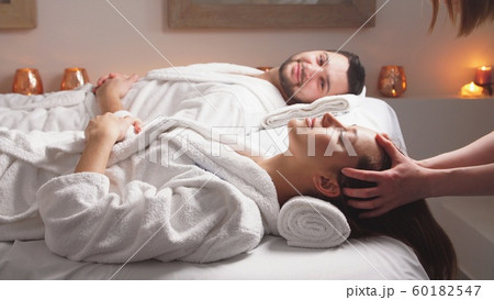 Charming couple enjoying a head massage in modern wellness salon. Charming couple enjoying a head massage in modern wellness salon. 60182547