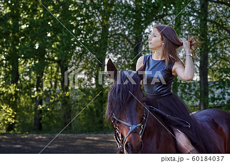 Young slim woman brunette in a black dress sitting Young slim woman brunette in a black dress sitting 60184037