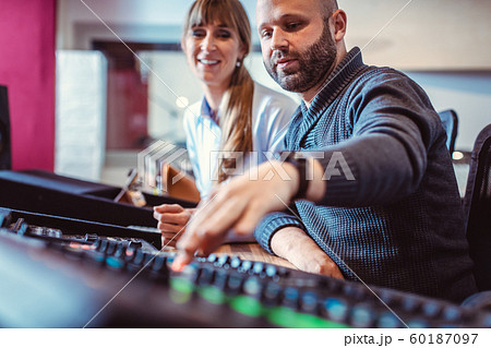 Singer or artist and sound engineer working in the studio 60187097