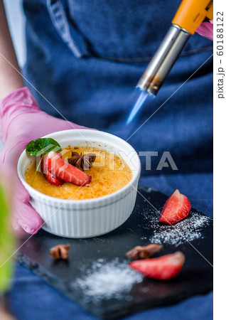 Bowl with creme brulee on a dark background. 60188122