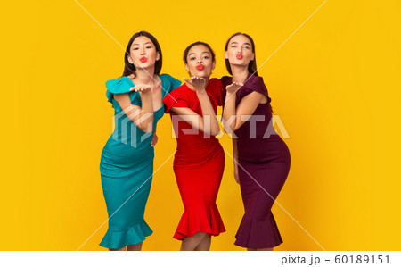 Three Diverse Girls In Dresses Sending Air Kiss, Studio Shot 60189151
