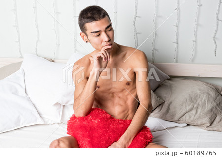 Young handsome man rest in bed. Sexy naked guy is 60189765