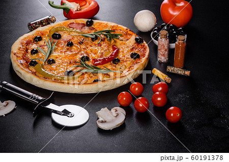 Tasty fresh hot pizza against a dark background Tasty fresh hot pizza against a dark background 60191378